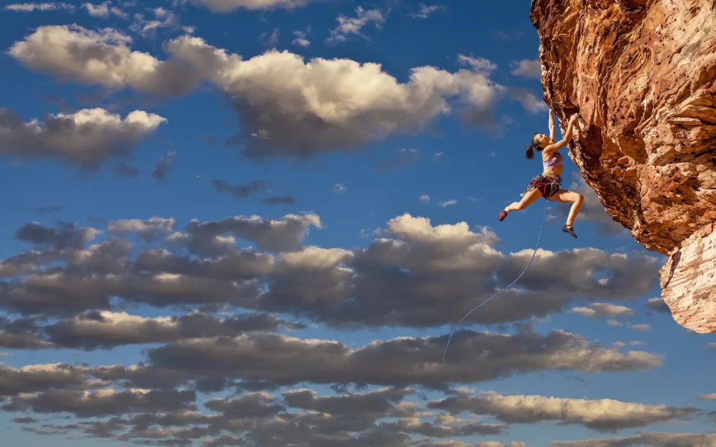 PAR with free climbing woman hanging at the mountain